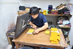Mann bereitet gelbe Schablonen am Arbeitstisch vor