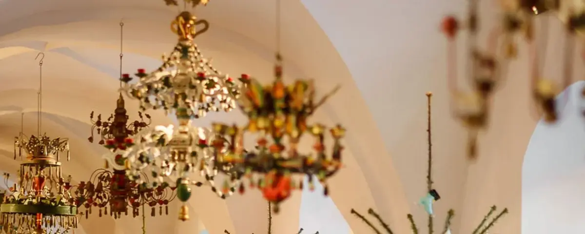 Besucher in einem Raum mit unter anderem verschieden geschmückten Weihnachtsbäumen