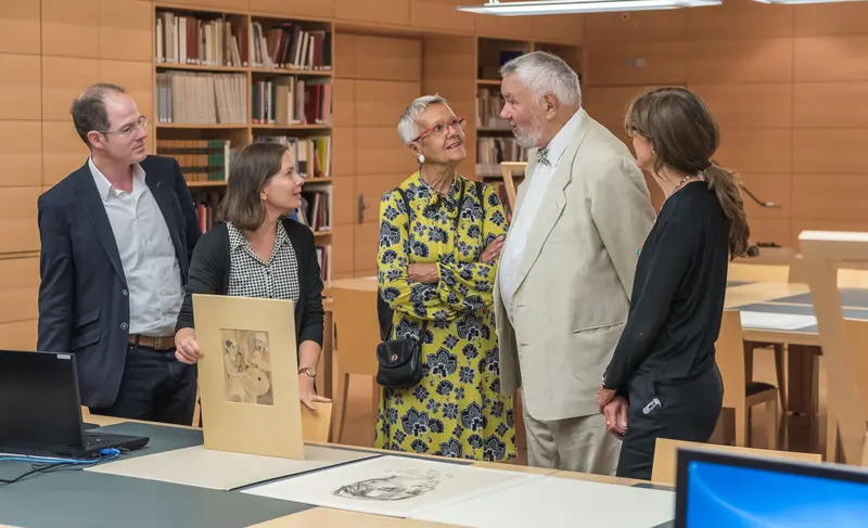 Personen im Kupferstich-Kabinett an einem Tisch mit graphischen Werken