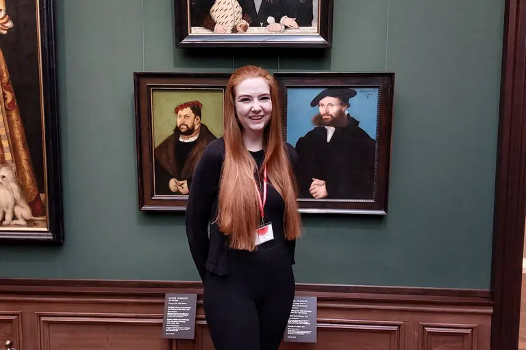 junge Frau vor mehreren Gemälden der Gemäldegalerie Alte Meister