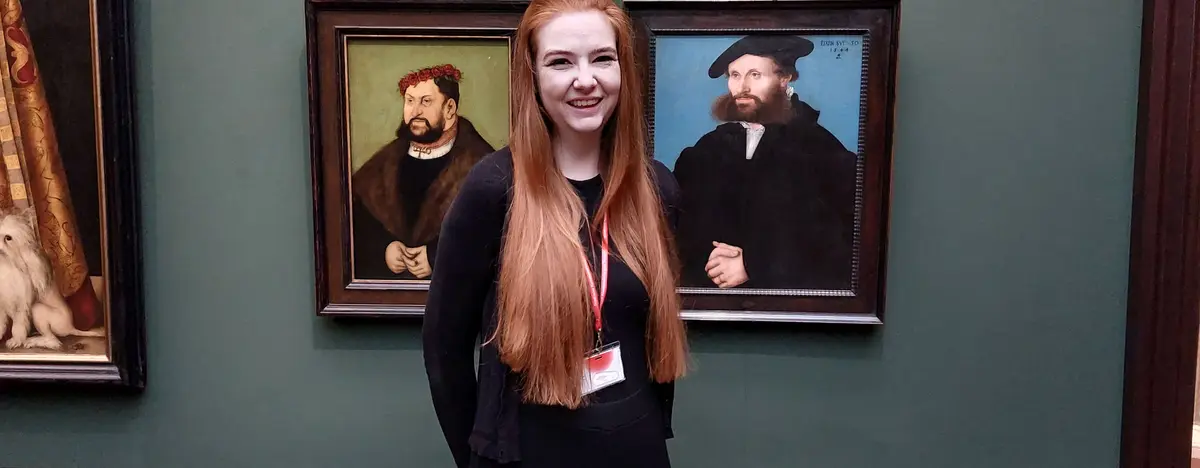 junge Frau vor mehreren Gemälden der Gemäldegalerie Alte Meister