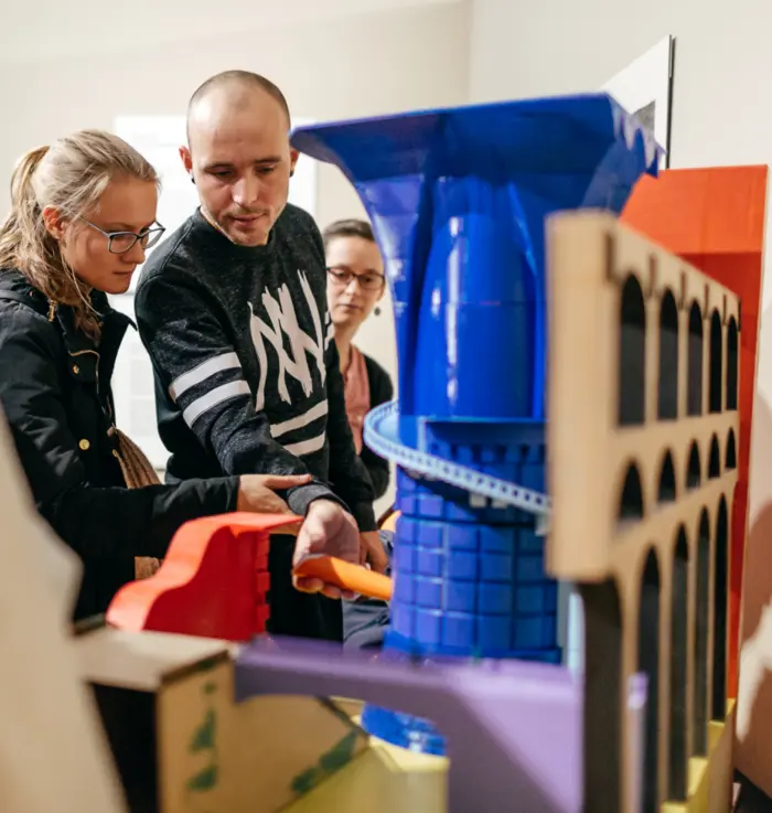 Besucher in der Ausstellung „Begegnungen mit Rom – Druckgraphik des 18. Jahrhunderts“ am Tastmodell „Piranesi 3D"