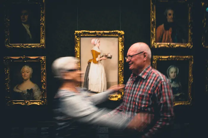 Ein alter Mann und eine alte Frau tanzen zusammen in einem Ausstellungsraum