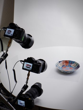 Foto mit drei Kameras auf Stativen, die eine Schale fotografieren.